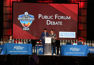 Public Forum Debate: Students competing at the 2023 National Tournament on stage.