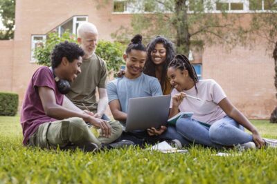 Students outside studying on the grass