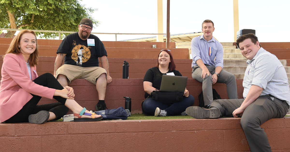 Group of people sitting together looking at the camera