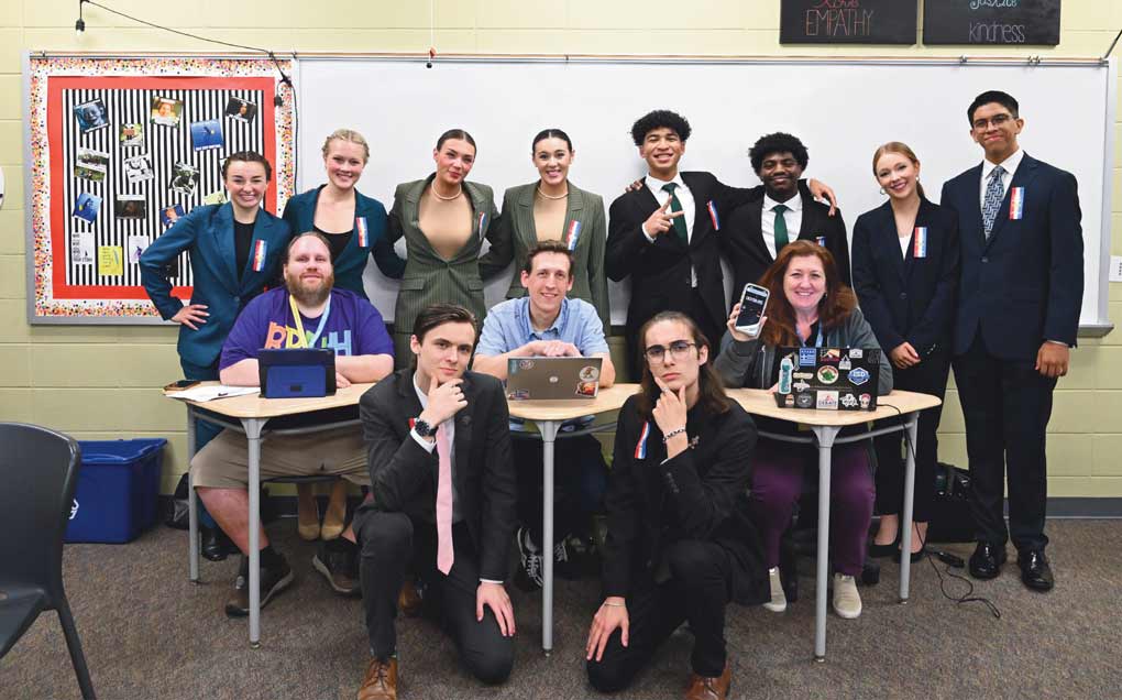 Group of students sitting in a classroom posing for a picture