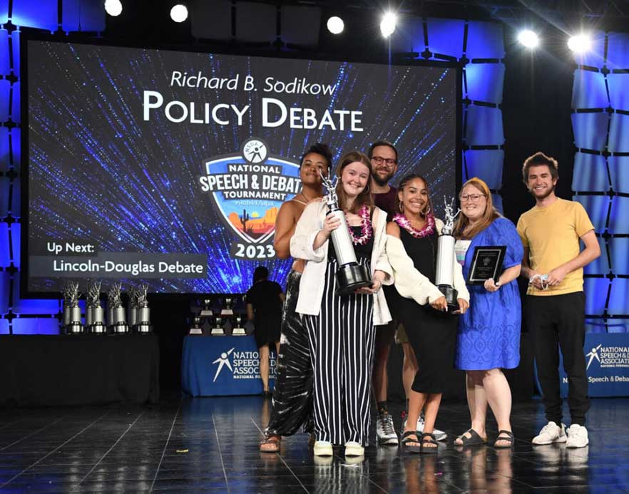 Group of students on the stage with their trophies at the National Tournament Group of students on the stage with their trophies at the National Tournament