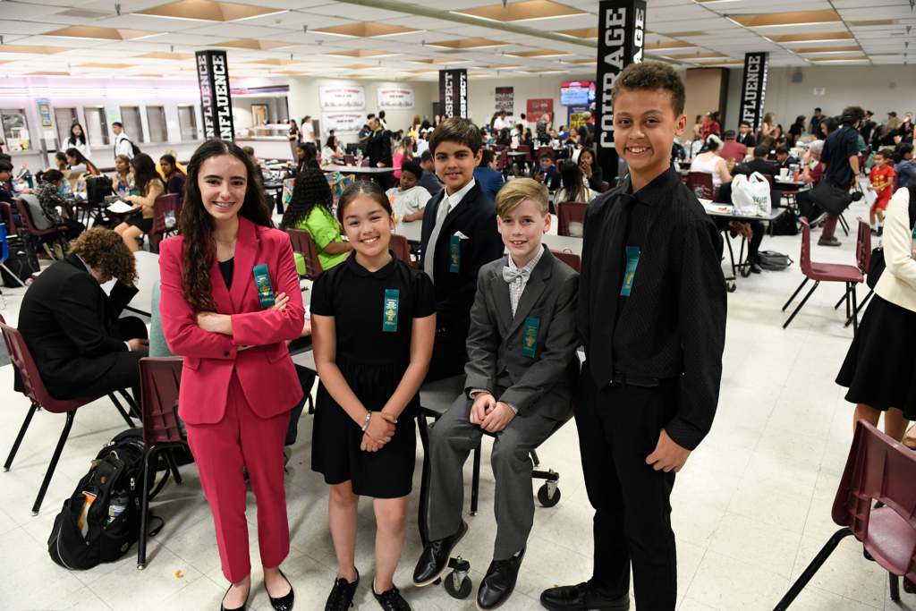 Group of students posing for a photo in a large room