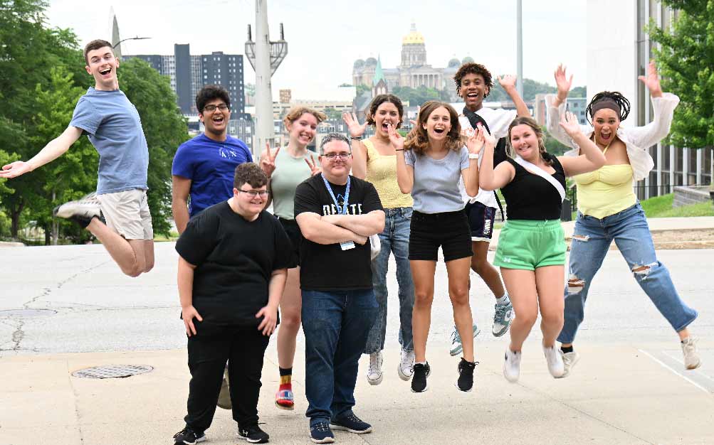 Group of people at posing for a picture jumping at the National Tournament