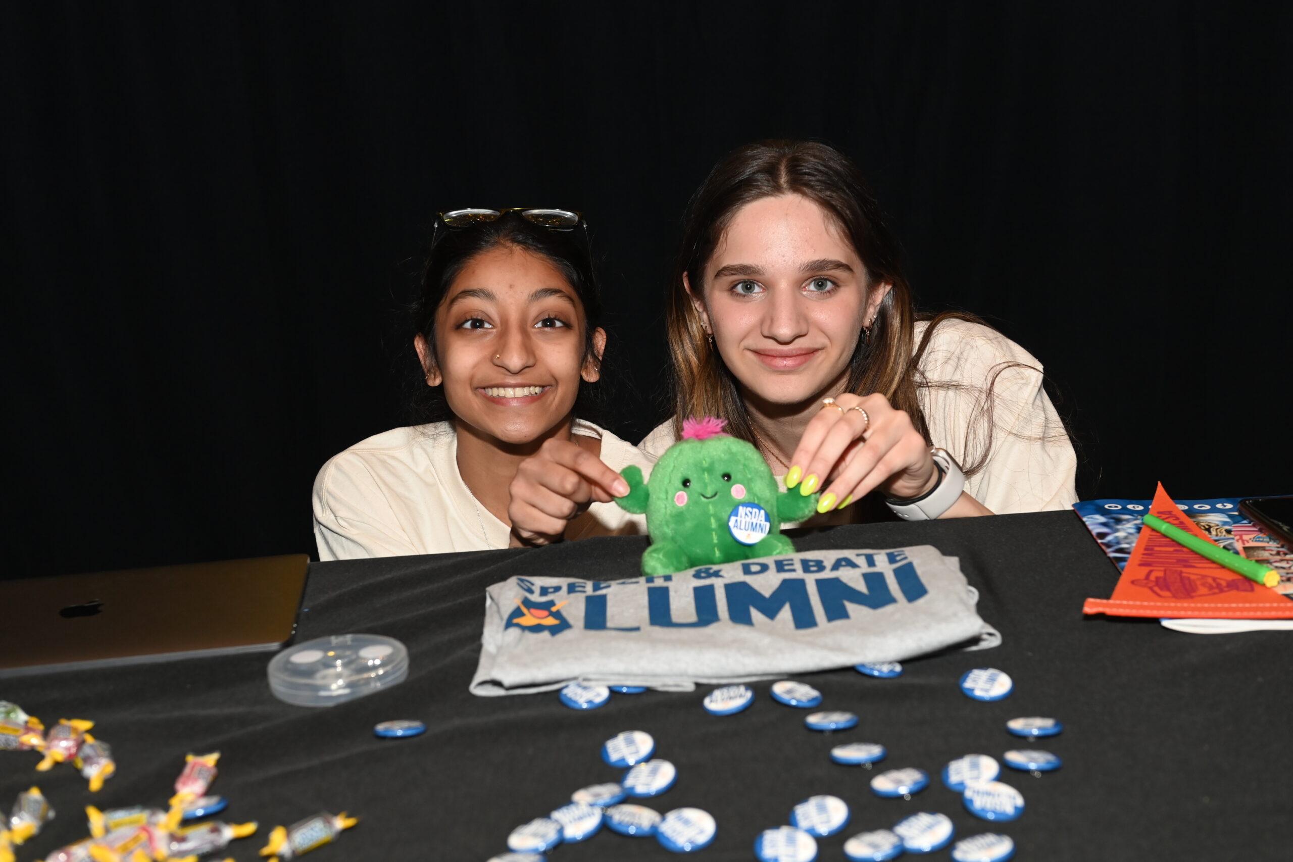 Two students posing with prickles the NSDA plush for Nationals 23