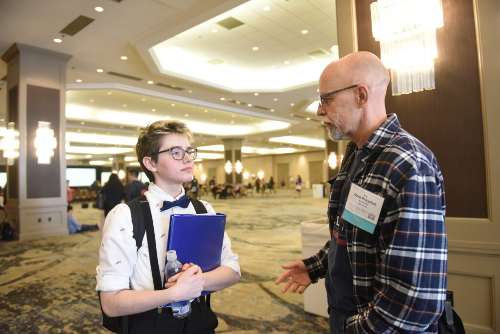 Coach and a student talking together at a tournament