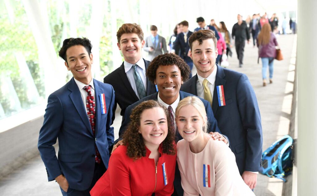 Group of students posing together in a walkway smiling after a tournament