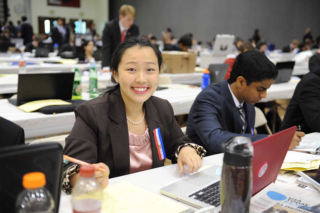 Student sitting at a computer smiling