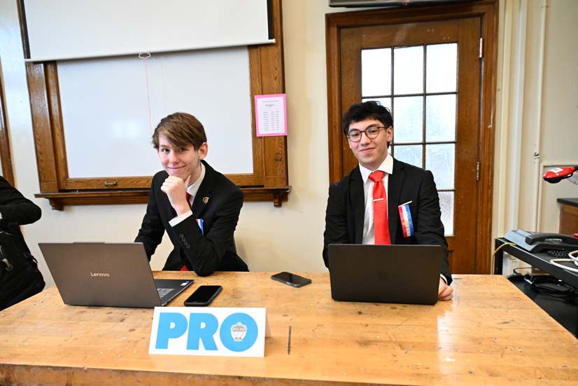Two students posing behind a desk at a tournament 