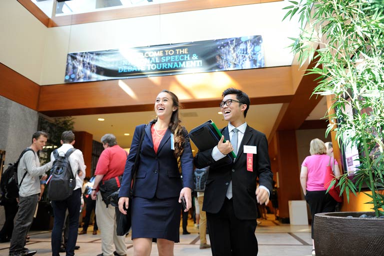 Two students walking down a hall at a tournament