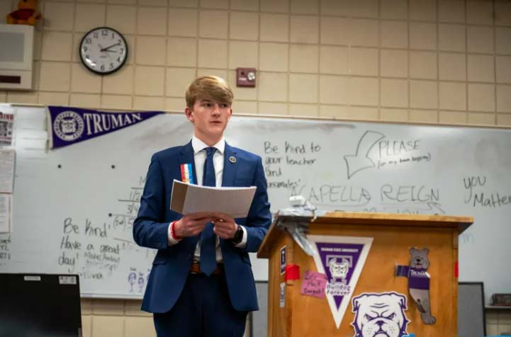 Student competing at the National Tournament holding paper