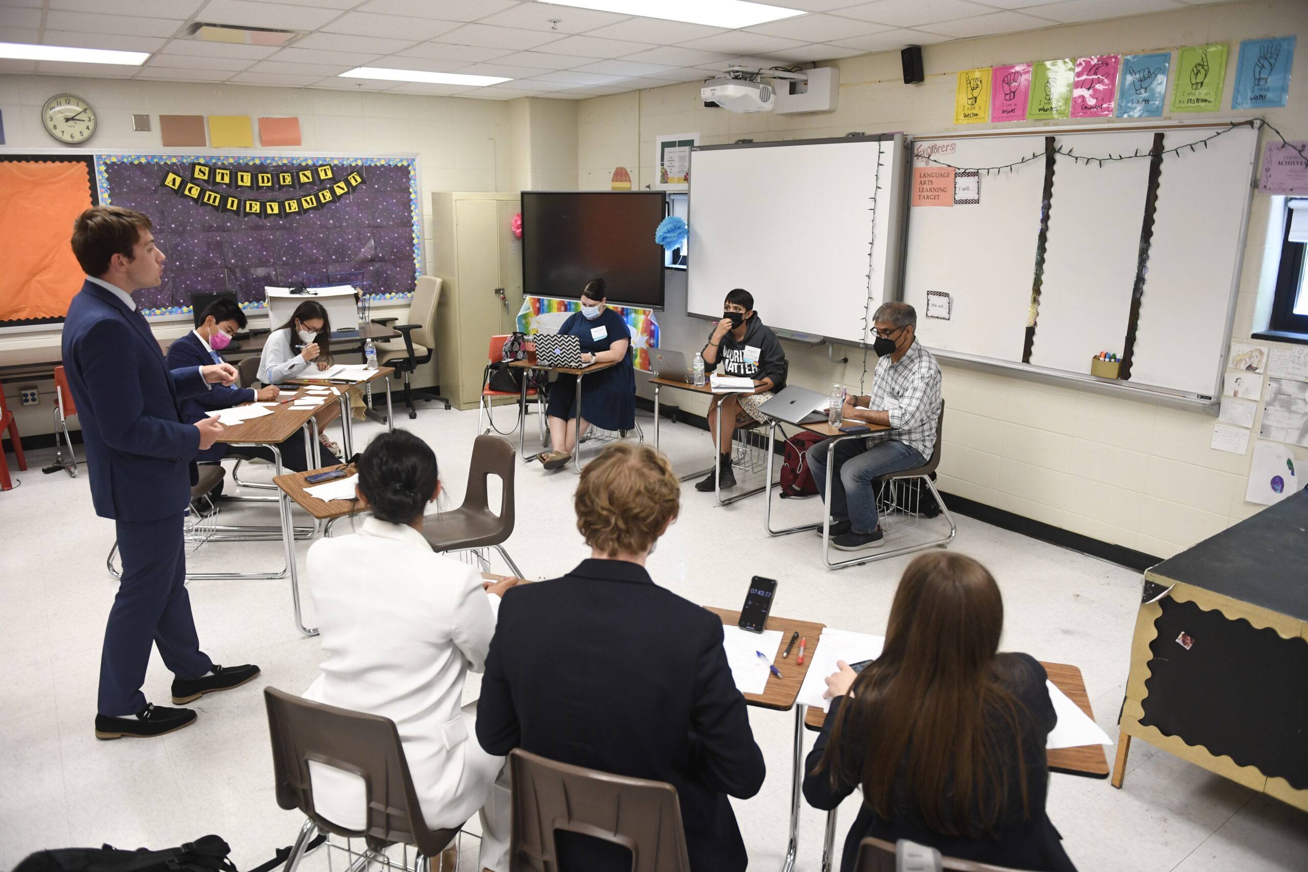 Judges watching 2 students perform