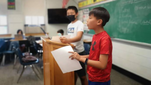 Group of students speaking in front of classroom