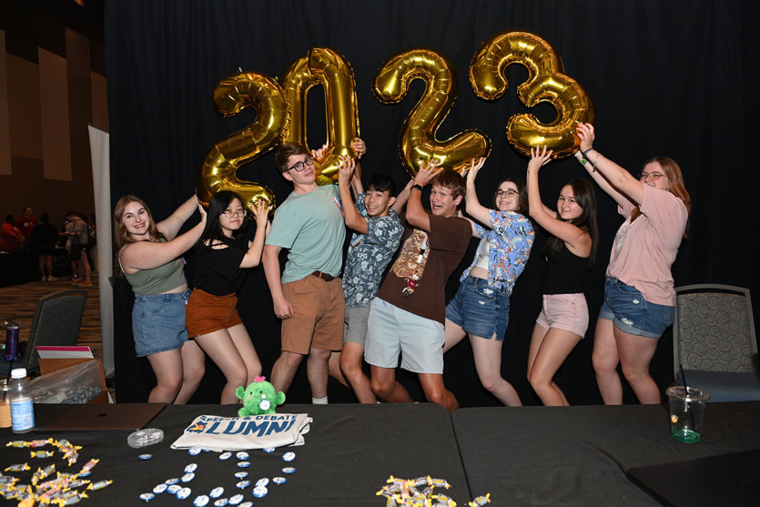 Group of students holding gold balloons representing 2023