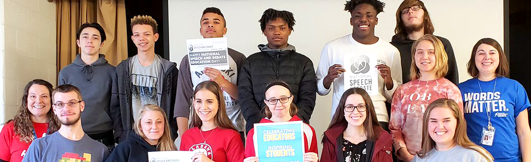 Students posing for a photo holding signs Students posing for a photo holding signs