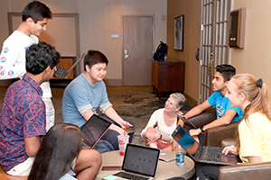 Students and coach gathered in a class with their laptops