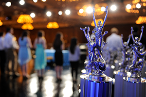 Collection of trophies with students in background