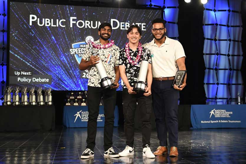 Group of students on the National Tournament stage with their trophies. Group of students on the National Tournament stage with their trophies.
