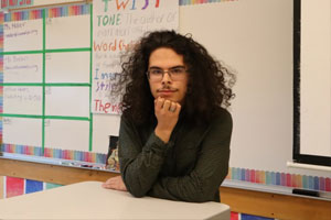 Person sitting behind a desk in a classroom