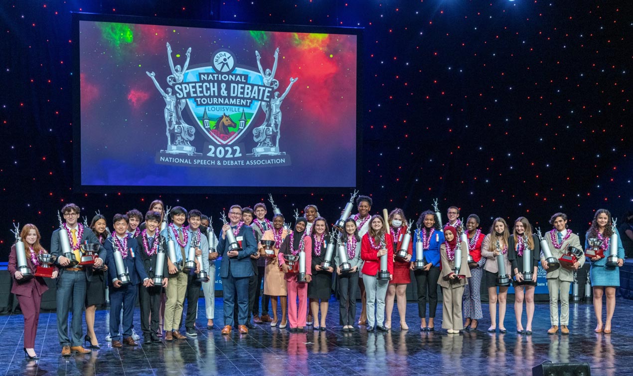 Group of students on stage with trophies at the National Tournament