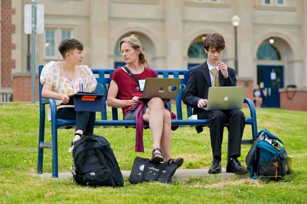 Coach sitting with their students on a bench working together Coach sitting with their students on a bench working together